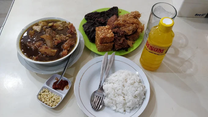 Seporsi Rawon Nguling khas Malang lengkap dengan nasi, empal, telur, tempe goreng dan sambal, jadi salah satu kuliner wajib di Malang yang legendaris.